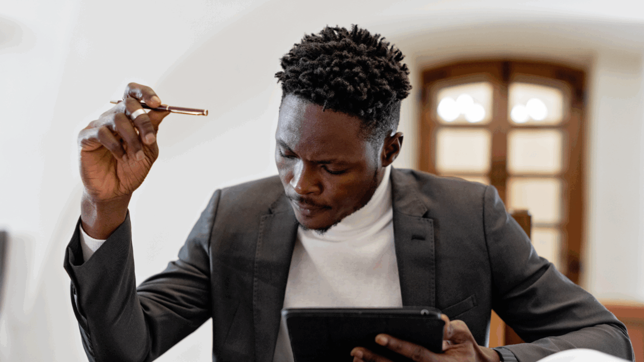 A man in a suit uses a tablet, representing support for vendors on Black Wall Street.