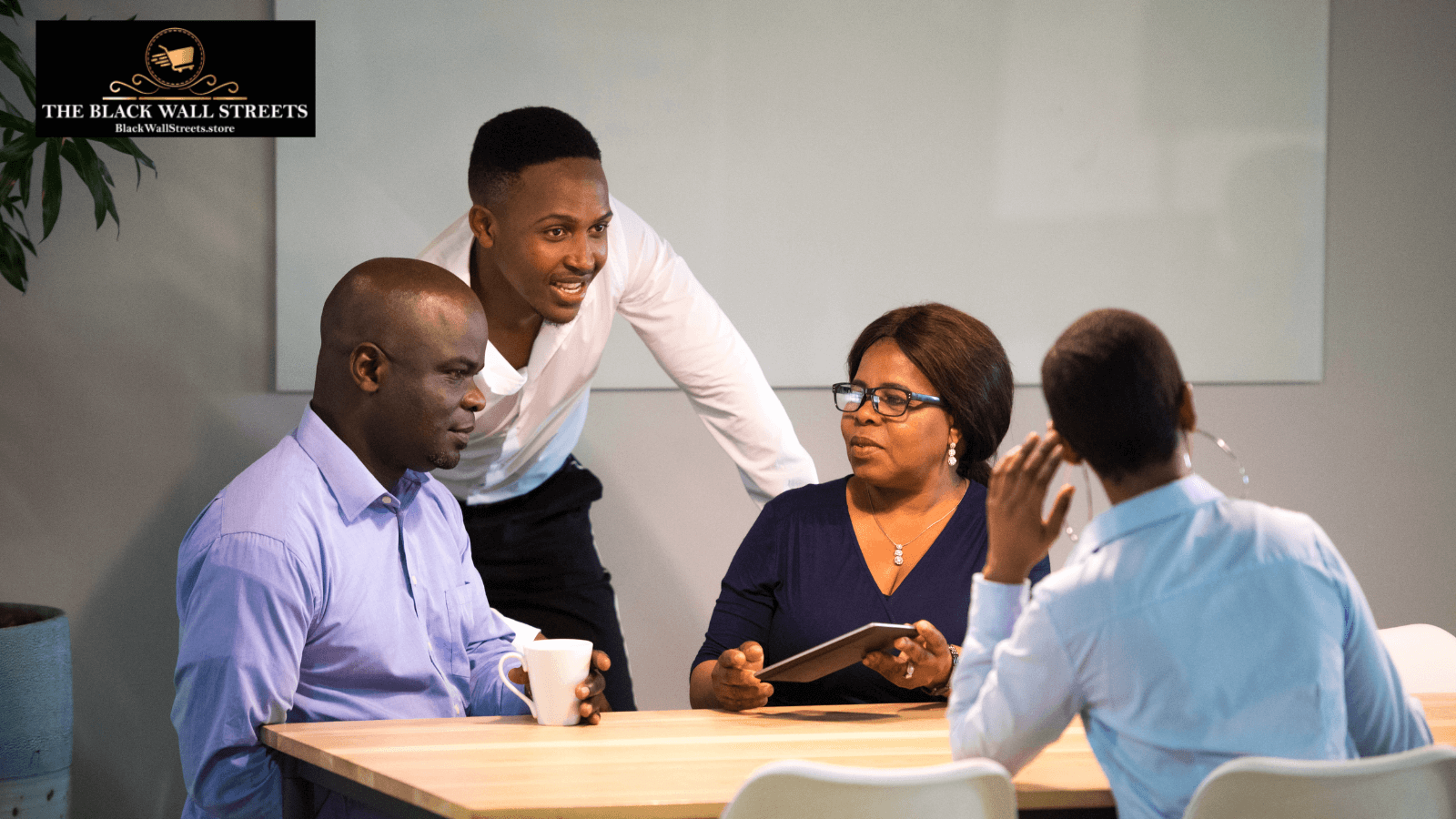 Three people at a table, with a man focused on a tablet, discussing vendor registration and product listings.